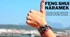 a hand giving a thumbs-up while wearing a decorative feng shui bracelet, set against a blurred cityscape background