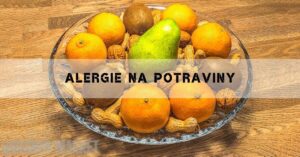 a glass bowl with oranges, peaches, kiwi, peanuts, and walnuts commonly associated with potravinová alergie