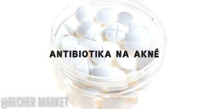 a clear glass container filled with white antibiotic pills, often used for treating skin conditions like acné (acne)