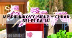 three dark bottles of mišpulníkový sirup with checkered pink ribbons tied around their necks, placed outdoors.