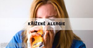 a person blowing their nose with tissue while holding allergy medication, illustrating symptoms of respiratory discomfort.