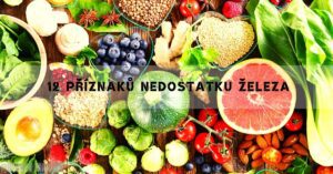 a colorful assortment of iron-rich foods like spinach, nuts, seeds, citrus fruits, avocado, and berries on a wooden table.