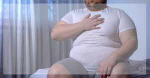 a person sitting on a bed clutching their chest, possibly indicating psychosomatic chest pressure or distress.